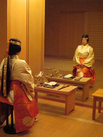 Photo of a costumed Japanese actor before a mirror